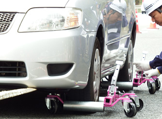 写真：【車両簡易移動器具による放置乗用車の人力による移動訓練】