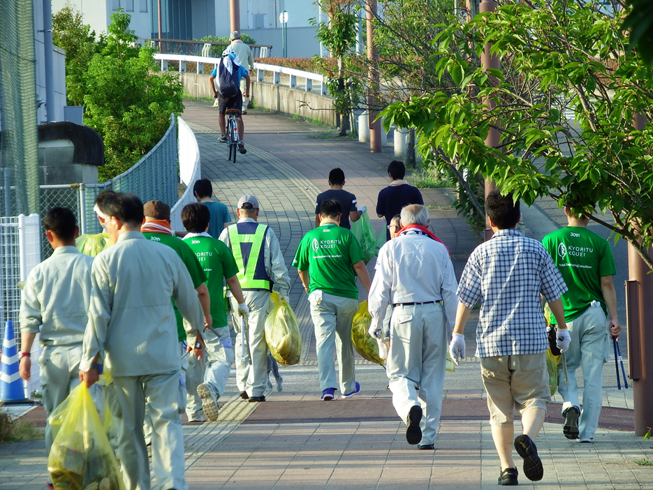 写真：【拾い集めたゴミを持って集合場所の愛媛県武道館前に向かう参加者】