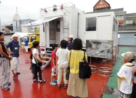 写真：【対策本部車の説明を受ける参加者たち】