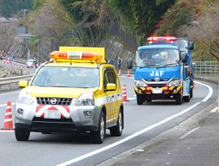 写真：【道路パトロールカーの先導により、ＪＡＦ作業車による放置トラックの移動作業】