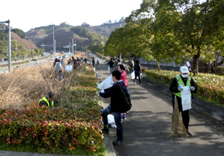 写真：【おもてなしの心をこめて、ゴミ拾いや除草に汗を流す参加者】