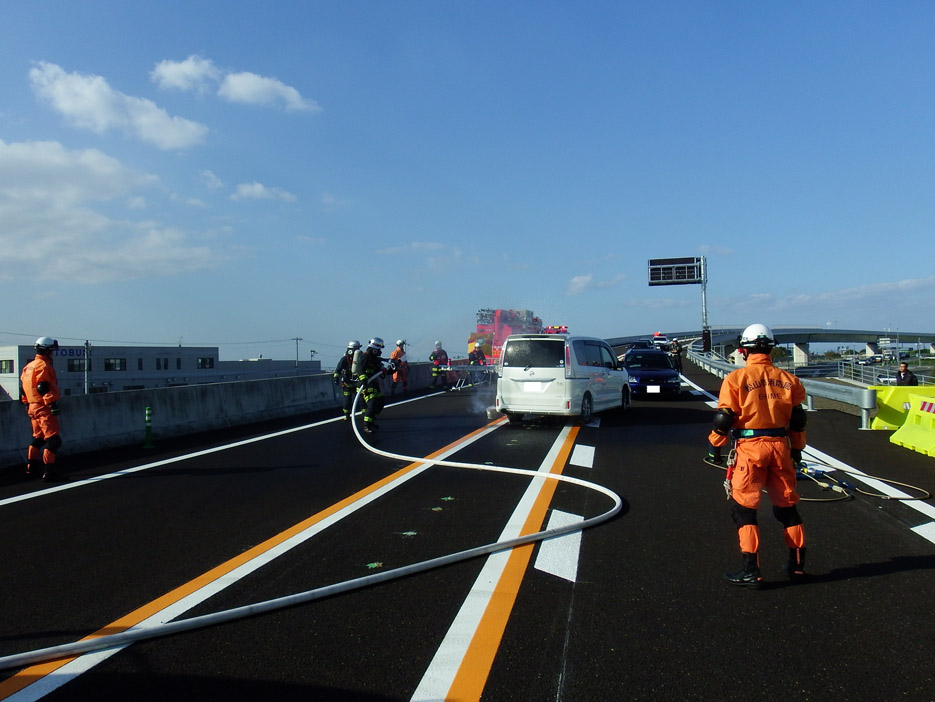 写真：【負傷者搬送後に出火した事故車両の消火活動】