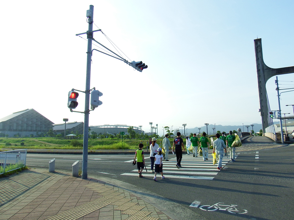 写真：【拾い集めたゴミを持って集合場所の愛媛県武道館前に向かう参加者】
